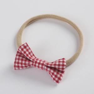 Close-up of red and white checkered pattern bow on soft nylon headband for infants