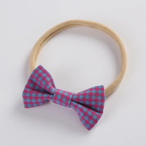 Detail of pink and blue plaid fabric bow on ultra-soft elastic nylon baby headband