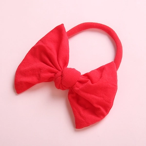 Detailed close-up of a soft red nylon baby headband with a large handmade bow knot