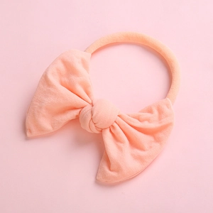 Detailed texture of ultra-soft pink bow headband made from knitted nylon fabric