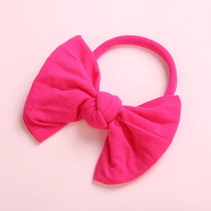 Detailed view of the soft knitted texture and bow design on this magenta baby headband