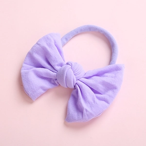 Detail of soft lavender nylon baby headband featuring a large elastic bow design