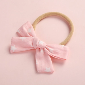 Dettaglio della fascia per neonata rosa con stelle e morbido cinturino in nylon senza cuciture