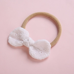 Bandeau bébé en nylon doux avec un nœud papillon en dentelle de coton sur fond rose
