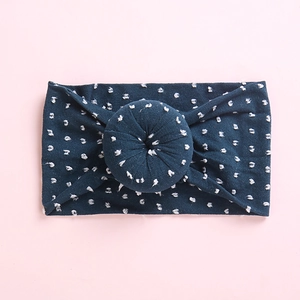 Diadema suave de nailon para bebé en azul marino con lunares blancos y nudo de dónut