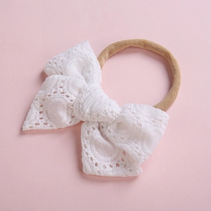 Gros plan détaillé du bandeau en dentelle pour bébé avec motif floral et bande élastique