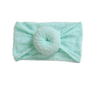 Diadema de nailon verde menta para bebé con lunares blancos y un suave nudo de donut
