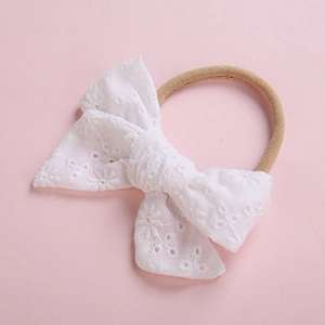 Bandeau élastique pour bébé orné d'un délicat nœud en dentelle blanche brodée pour fille