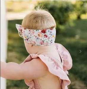 Floral print baby headband detail showing fit and soft fabric texture on infant model