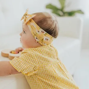 Soft baby headband with yellow daisy floral bow print and comfortable elastic wide band