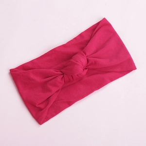 Close-up of rose red nylon baby headband featuring a soft knot and elastic knit texture
