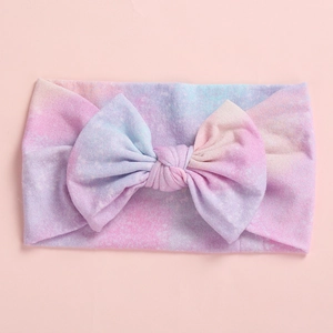 Detail of soft knit baby headband with large bow in colorful pastel tie-dye print