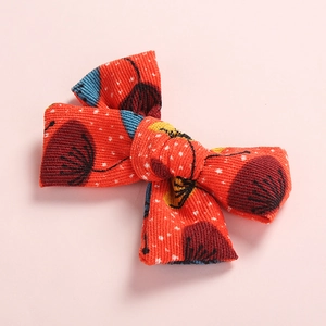 Red floral print corduroy bow hair clip for girls with white dots on pink background