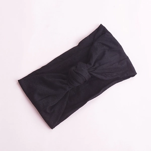 Detail of soft black nylon baby headband with classic knot design on flat background