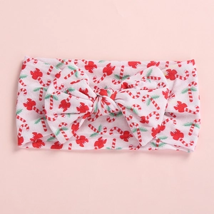 Detail view of baby headband with Christmas candy cane pattern and red bow decoration