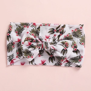 Detail of baby headband with green palm leaf print and large soft fabric bow