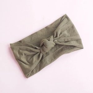 Close-up of olive green soft nylon baby headband with a handcrafted knot detail