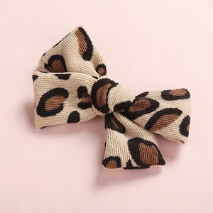 Macro shot of leopard print corduroy fabric bow hair clip with fine ribbed texture