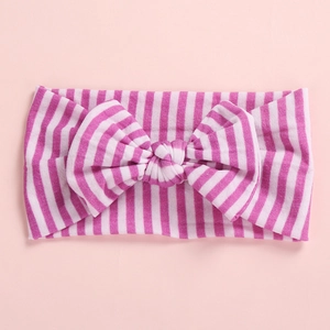Detailed close-up of pink and white striped baby headband with a large soft bow design