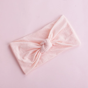 Detail of soft baby nylon headband showing elastic knitted texture and central knot design