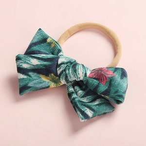 Detail of teal floral corduroy bow headband with high-elasticity nude rubber strap