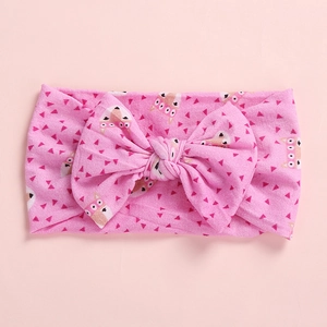 Detailed view of pink baby headband with large bow and cartoon fox prints