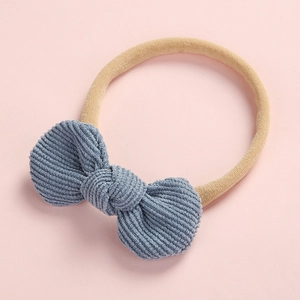 Détail du nœud bébé en velours côtelé bleu avec un bandeau en nylon souple et élastique