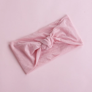 Detailed view of the soft pale pink knitted nylon baby headband with a decorative knot