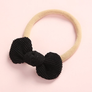 Détail d'un bandeau bébé avec nœud en velours côtelé noir et ruban en nylon