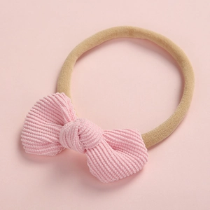 Détail d'un bandeau rose en velours côtelé avec nœud doux pour nouveau-nés et bébés