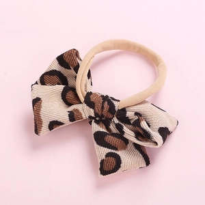 Close-up of leopard print corduroy hair bow with high-elastic beige headband for girls