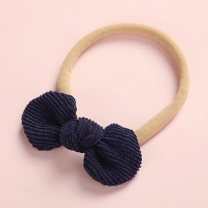 Détails du nœud en velours côtelé bleu foncé sur un bandeau bébé en nylon doux