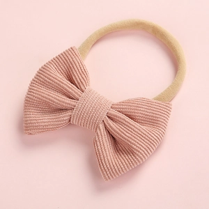 Détail du nœud en velours côtelé rose et bandeau élastique pour bébés filles