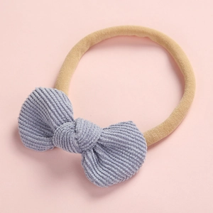 Détail de la texture en velours côtelé du bandeau bébé avec nœud et boucle en nylon doux