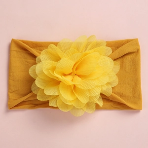 Detailed view of ginger yellow baby nylon headband with a large mesh chiffon flower