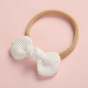 Bandeau bébé en velours côtelé blanc avec nœud et élastique doux sur fond rose