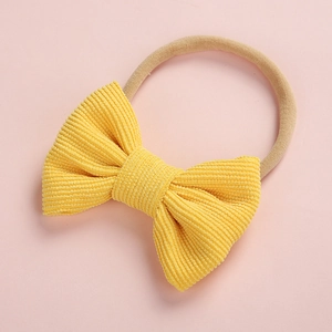 Détail du bandeau pour bébé avec nœud en velours côtelé jaune et ruban élastique doux