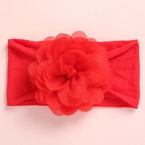 Detail of red baby headband featuring a large layered mesh flower on a soft elastic band