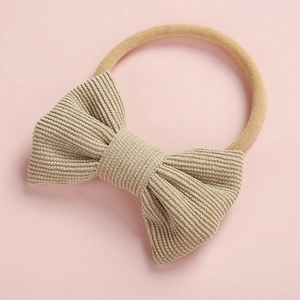 Détail d'un bandeau pour bébé avec nœud en velours côtelé beige et sangle en nylon