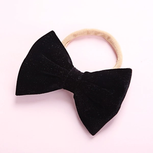 Close-up of soft black velvet bow headbands with elastic nylon bands for infants