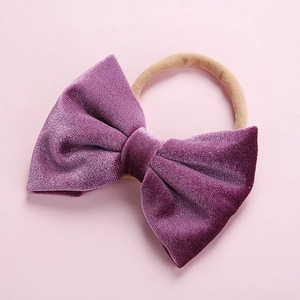 Detail of soft purple velvet bow on a seamless high-elastic headband for infants