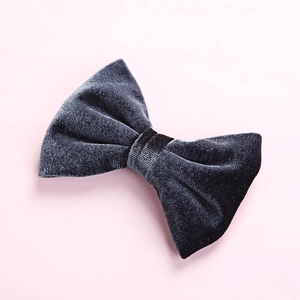 Close-up of velvet bow hair clip in dark navy blue showing soft fabric texture