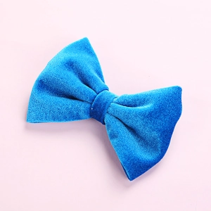 Detail view of a bright royal blue velvet bow hair clip for children with soft texture