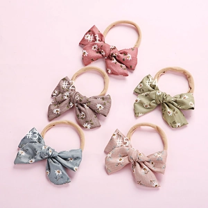 Detailed set of 5 floral bow headbands for babies with soft nylon bands and daisy patterns