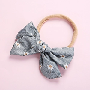 Soft nylon baby headband with a grey daisy print pinwheel bow for infants and toddlers