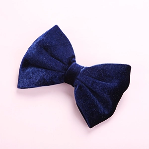 Detail showing the plush velvet texture and bow design of the navy blue hair clip