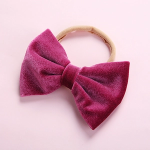 Detail of soft dark magenta velvet bow headband for infants with seamless elastic band