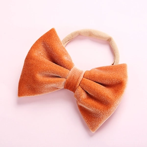 Detail of soft orange velvet bow headband with high-elastic seamless band for infants