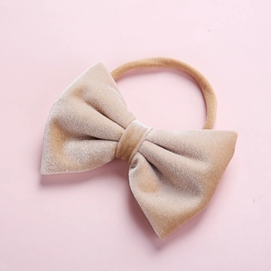 Close-up of a soft beige velvet bow headband for infants with high-elastic nylon band