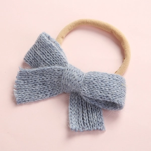 Macro shot of light blue hand-knitted bow and ultra-soft elastic headband for infants